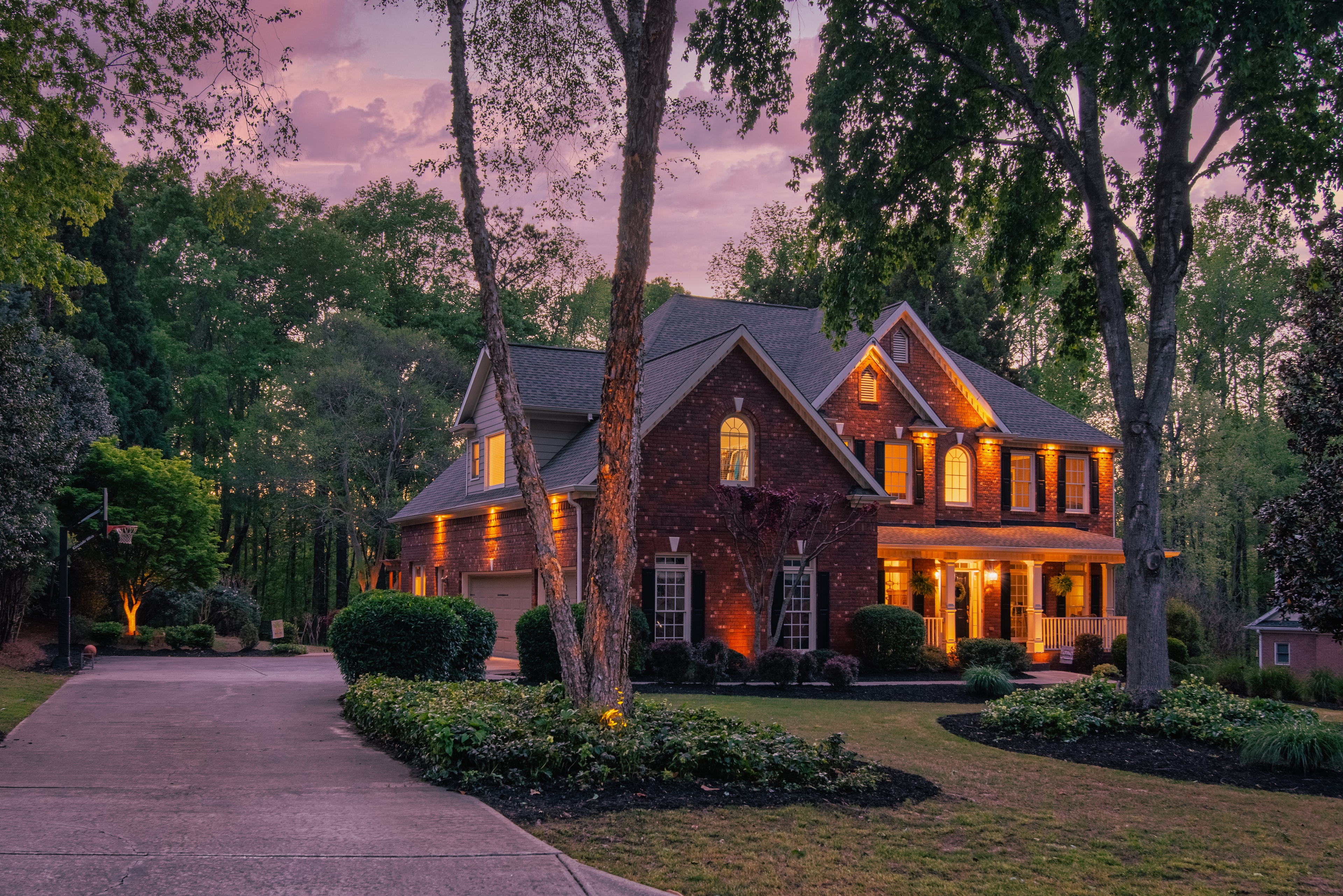 Brick home with warm exterior lighting at dusk